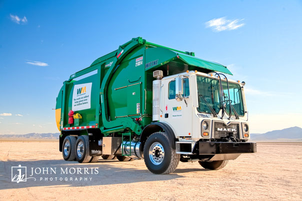 Giant green Waste Management Truck, modeled in the desert for a commercial, industrial photo shoot.