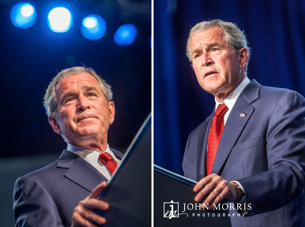 Bathed in blue light, President George Bush speaks confidently during a corporate event.