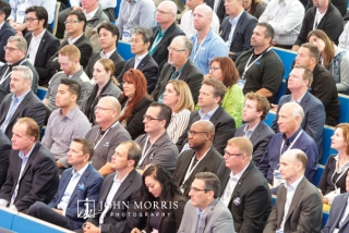 Seated crowd listening intently to a keynote speaker during a conference at the Aspen Institute Music Hall.