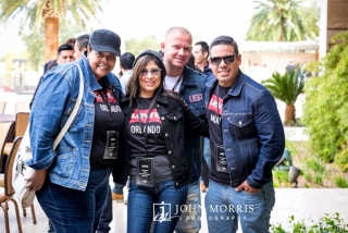Four attendees in denim apparel having fun and smiling for the camera during a networking event.