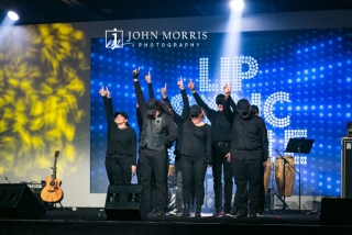 Lip sync group performing on stage during a corporate networking event.