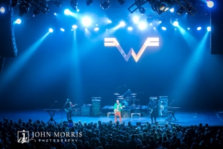 Weezer performing onstage at a corporate event