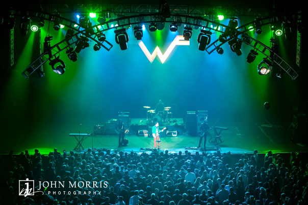Weezer on stage with enthusiastic crowd at a corporate event