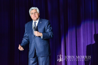 Comedian Jay Leno, delivers a monologue to during the entertainment portion of a corporate event.