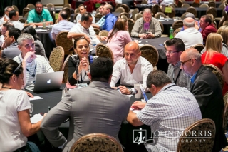 During a corporate breakout session, professionals sit around round tables and discuss important topics.