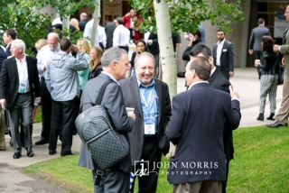 Group of businessmen sharing ideas and a laugh during an outdoor networking event at a conference in Aspen, CO.