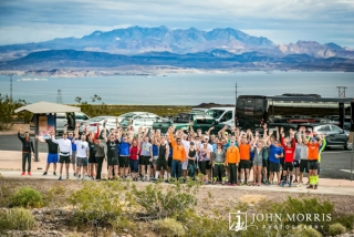 Large group of runners posing after running a corporate sponsored 5k event a with Lake Mead in the background.