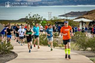 Runners starting out on a corporate sponsored 5k event with beautiful Lake Mead in the background