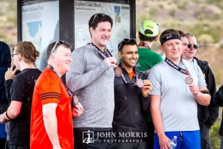Executive with attendees proudly showing off medals after running a corporate sponsored 5k event
