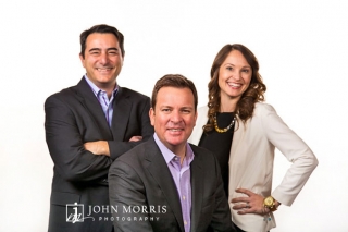 Three executives pose for the camera against a white backdrop in a casual, lifestyle way.