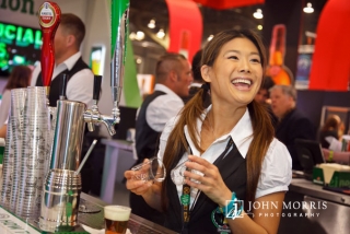 Bartender having a great time at a busy exhibit booth during a trade show.