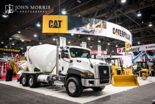 White cement truck on display inside a massive exhibit for Caterpillar construction vehicles inside an exhibit hall for a trade show in Las Vegas.